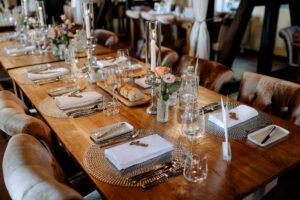 Festlich gedeckter Tisch in der Moormühle mit Kerzenleuchtern, Blumenarrangements und Brotkorb