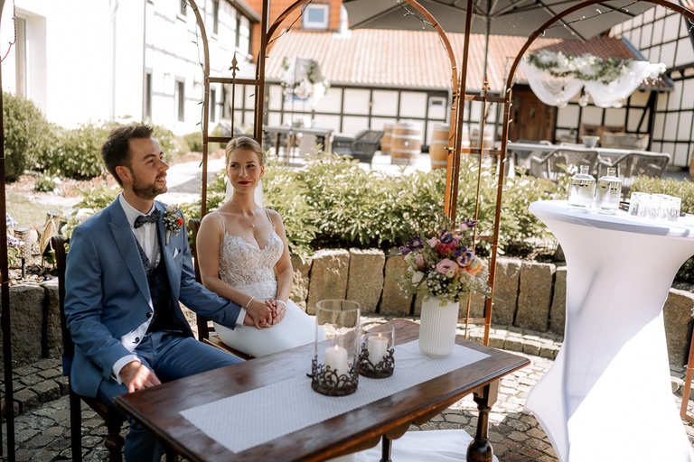 Hochzeitspaar bei der Trauung im Innenhof der Moormühle unter einem dekorierten Pavillon