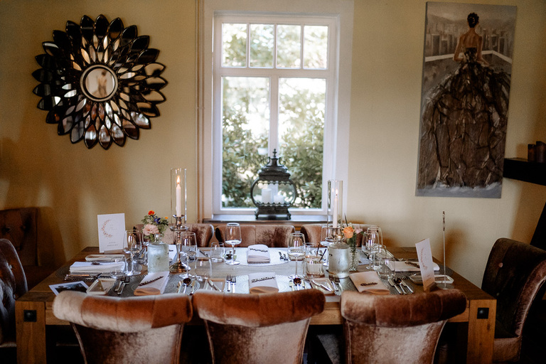 Festlich gedeckter Tisch in der Moormühle mit Kerzen, Blumen und Menükarten