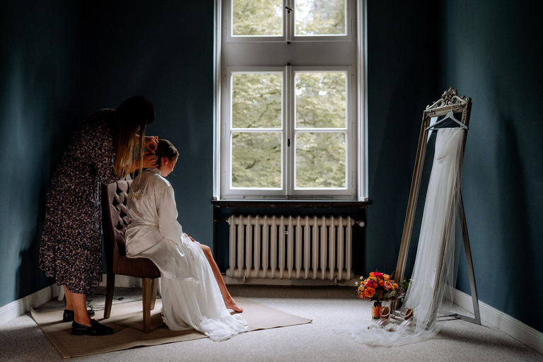 Braut wird von einer Visagistin im Schloss Eldingen geschminkt.