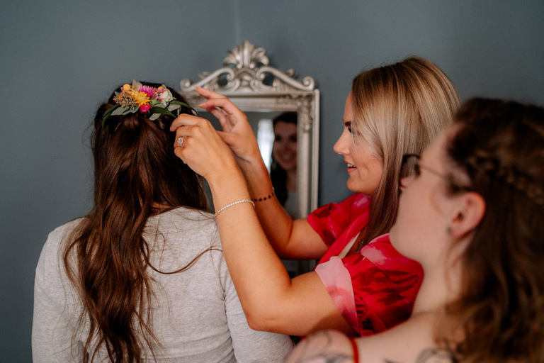 Blumenkranz wird als Haarschmuck am Hochzeitstag auf Schloss Eldingen befestigt.