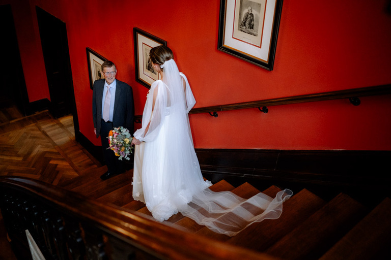 Die Braut geht mit ihrem Vater die Treppe auf Schloss Eldingen hinunter.