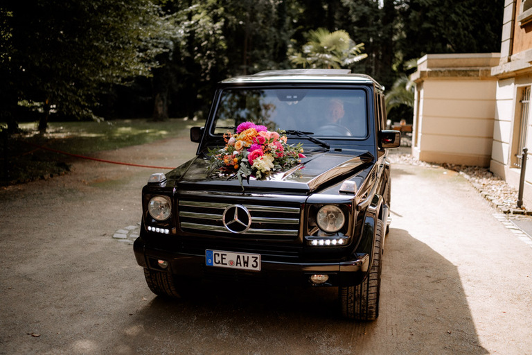 Elegantes Hochzeitsauto mit floraler Dekoration vor Schloss Eldingen.