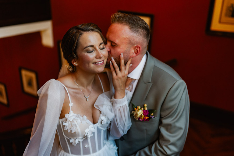 Das Brautpaar posiert romantisch auf der Treppe im Inneren von Schloss Eldingen.