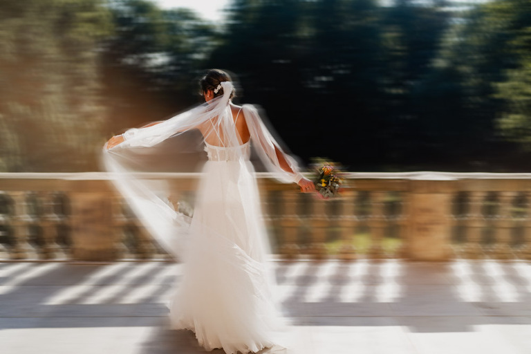 Braut auf der Terrasse von Schloss Eldingen, tanzend im fließenden Kleid.