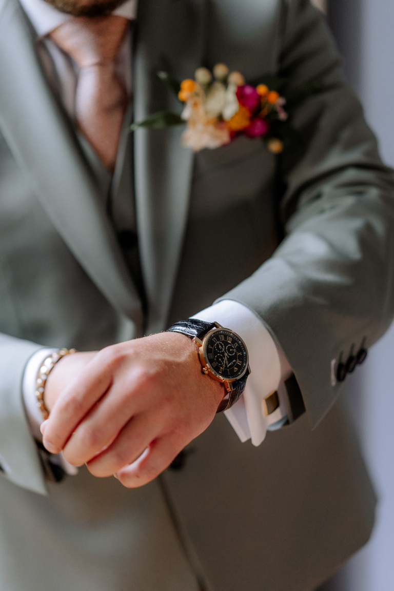 Bräutigam legt seine Uhr an, ein Moment der Vorbereitung für die Hochzeit auf Schloss Eldingen.