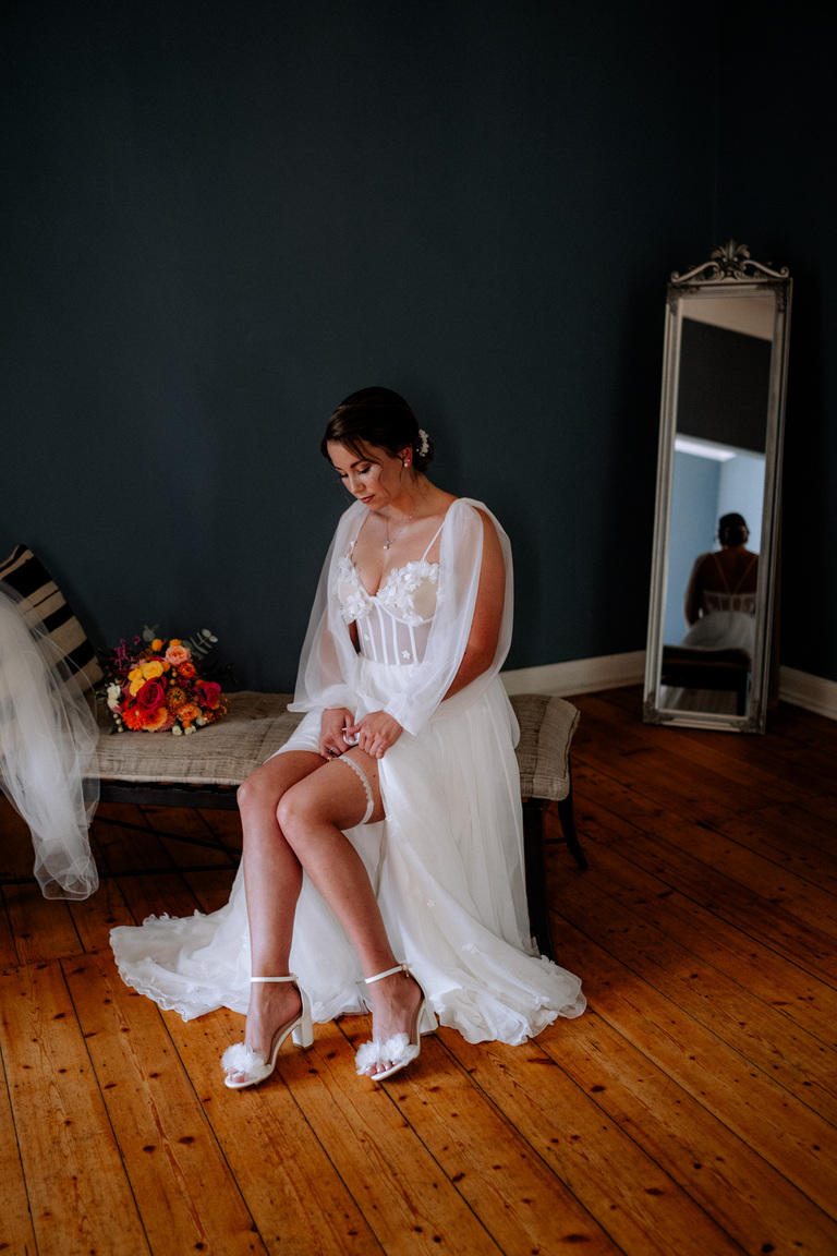 Die Braut sitzt in ihrem Kleid, bereit für den großen Moment, auf Schloss Eldingen.