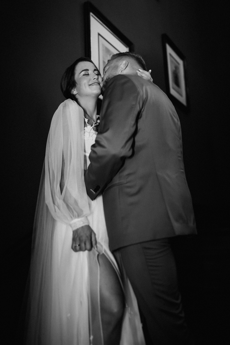 Schwarz-Weiß-Bild eines lachenden Brautpaars in romantischer Umarmung